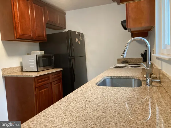 a kitchen with sink a refrigerator and cabinets
