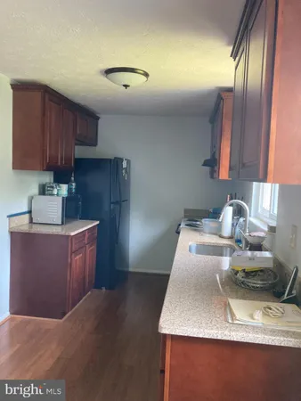 a kitchen with granite countertop a sink stainless steel appliances and cabinets