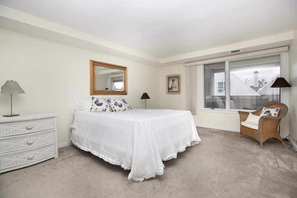 304 Commodore Court, Unit 304 Hull, MA 02045 - Photo 11 of 12 a spacious bedroom with a bed and a large window