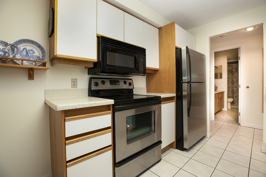 304 Commodore Court, Unit 304 Hull, MA 02045 - Photo 5 of 12 a kitchen with stainless steel appliances a stove microwave and a refrigerator