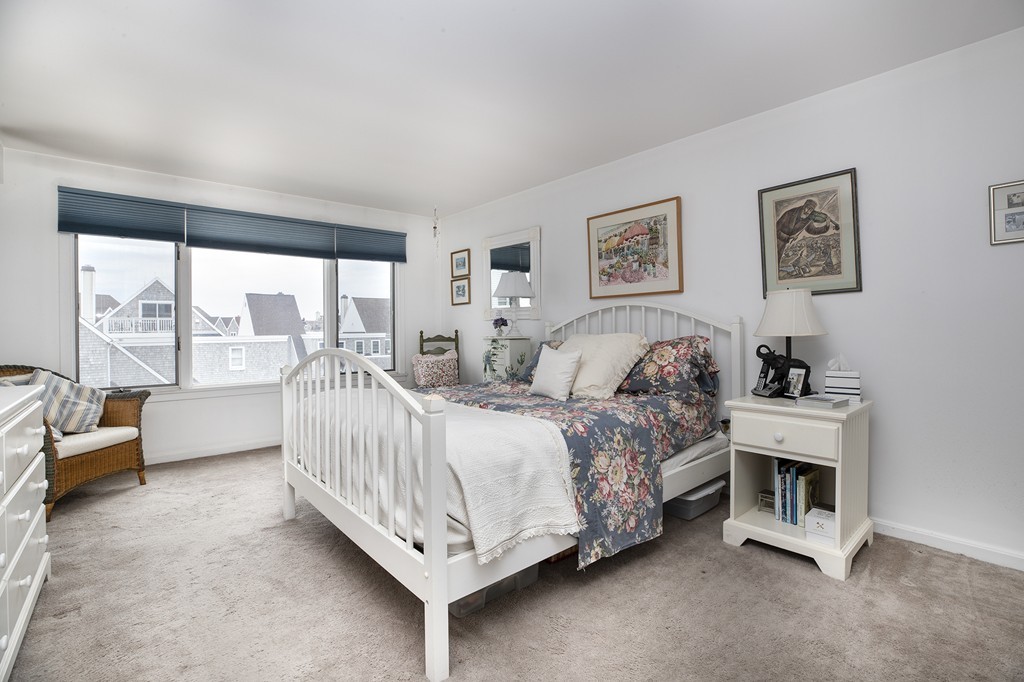 304 Commodore Court, Unit 304 Hull, MA 02045 - Photo 9 of 12 a bed room with a bed and a couch