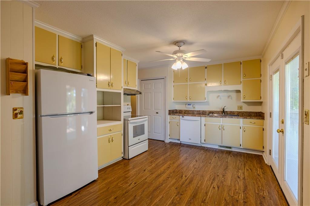 16 Drexel Drive Northwest Rome, GA 30165 - Photo 8 of 27 a kitchen with a refrigerator a sink cabinets and wooden floor