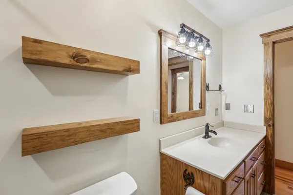 a bathroom with a sink a toilet and mirror