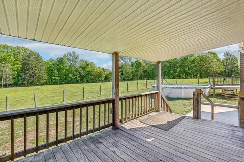 a view of a house with a yard and wooden fence