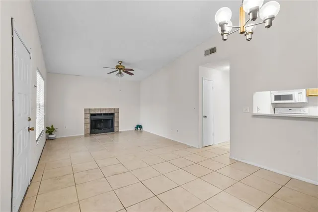 wooden floor in an empty room with a chandelier fan