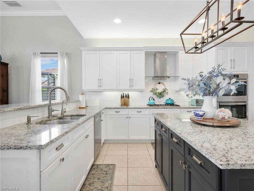 2756 Crystal Way Naples, FL 34119 - Photo 20 of 50 a kitchen with stainless steel appliances granite countertop a sink stove and cabinets