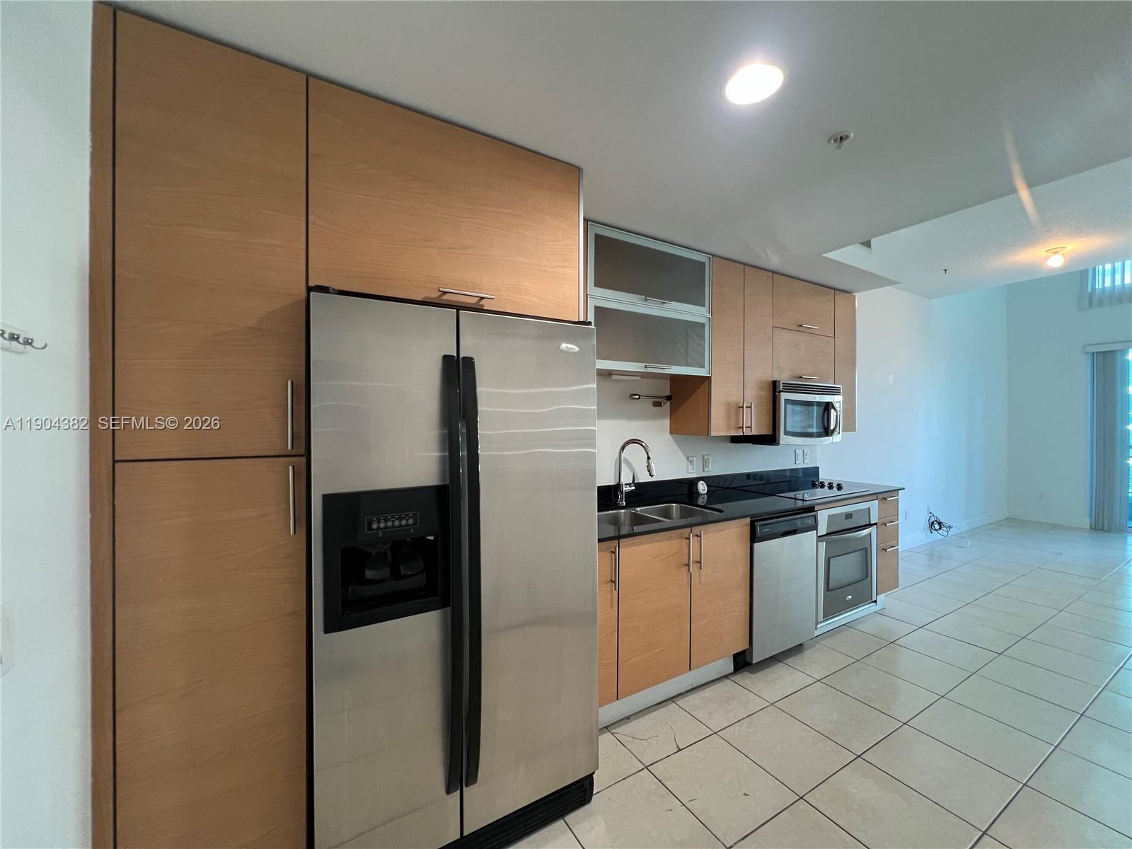 60 Southwest 13th Street, Unit 1612 Miami, FL 33130 - Photo 14 of 24 a kitchen with stainless steel appliances granite countertop a refrigerator and a stove top oven