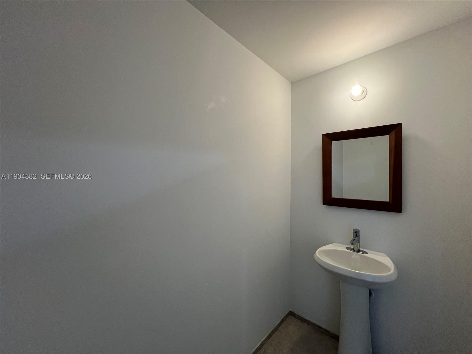 60 Southwest 13th Street, Unit 1612 Miami, FL 33130 - Photo 16 of 24 a bathroom with a sink and a mirror