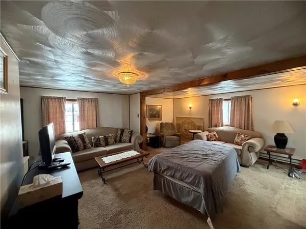 a spacious bedroom with a bed and a chandelier
