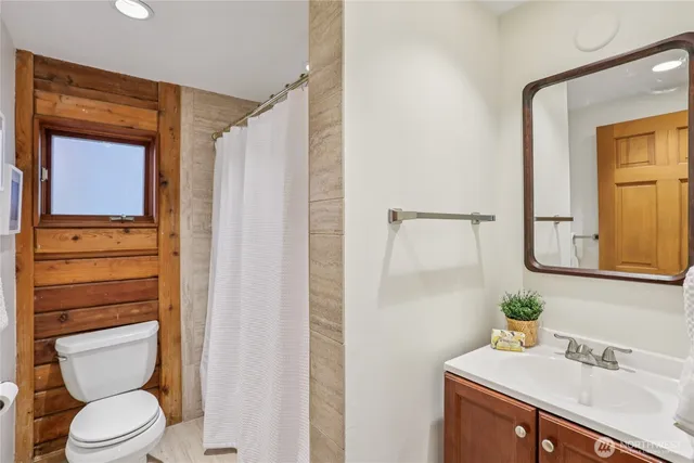 a bathroom with a toilet a sink and a mirror