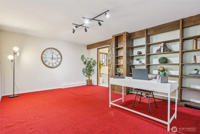 a view of a room with a large window and wooden floor