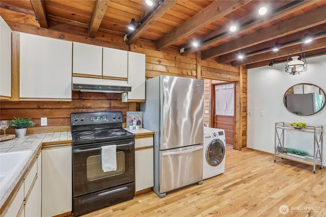 a kitchen with refrigerator and a stove