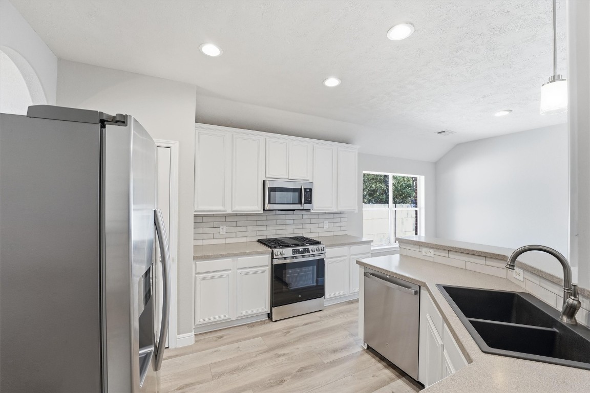 23301 Tuttle Court Porter, TX 77365 - Photo 19 of 50 a kitchen with a refrigerator sink and stainless steel appliances