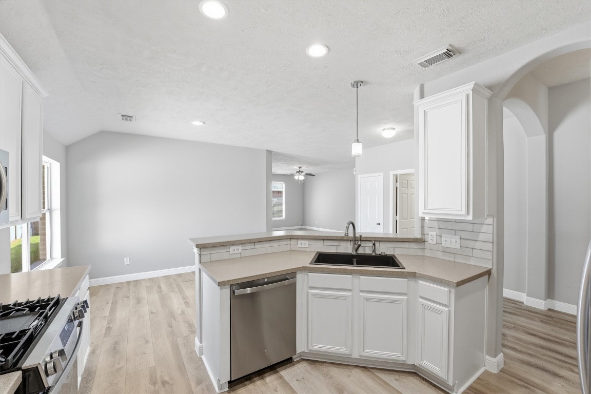 23301 Tuttle Court Porter, TX 77365 - Photo 20 of 50 a kitchen with granite countertop a sink stainless steel appliances and white cabinets