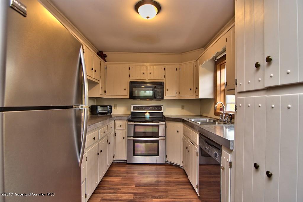 5275 Bloomington Road Moscow, PA 18444 - Photo 18 of 48 a kitchen with stainless steel appliances granite countertop a refrigerator a stove top oven a sink and dishwasher
