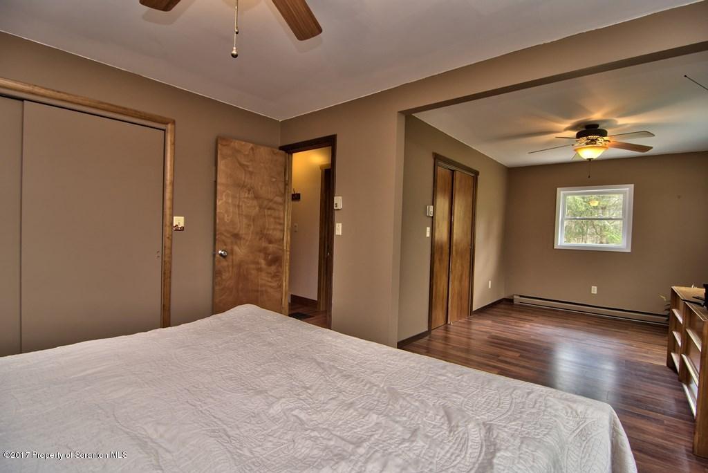 5275 Bloomington Road Moscow, PA 18444 - Photo 36 of 48 a bedroom with a bed and a chandelier