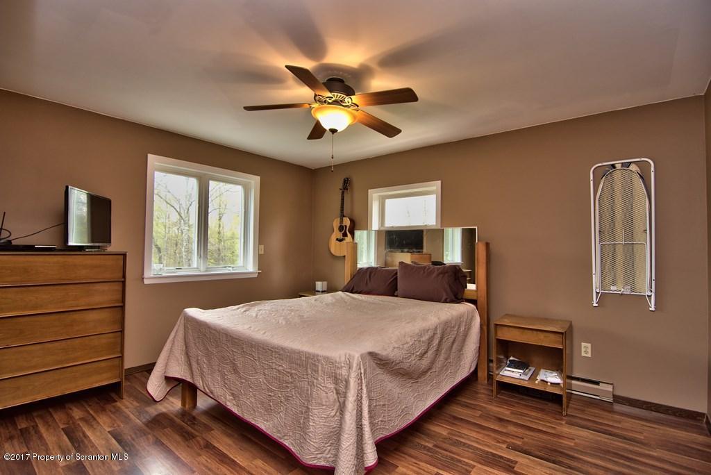 5275 Bloomington Road Moscow, PA 18444 - Photo 38 of 48 a bedroom with a bed and wooden floor