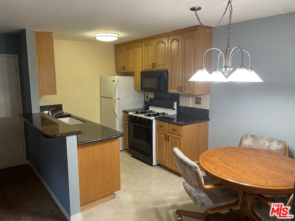 3640 Cardiff Avenue, Unit 108 Los Angeles, CA 90034 - Photo 6 of 14 a kitchen with sink a refrigerator and chairs