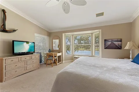 a large bedroom with a large bed and flat tv screen on dresser
