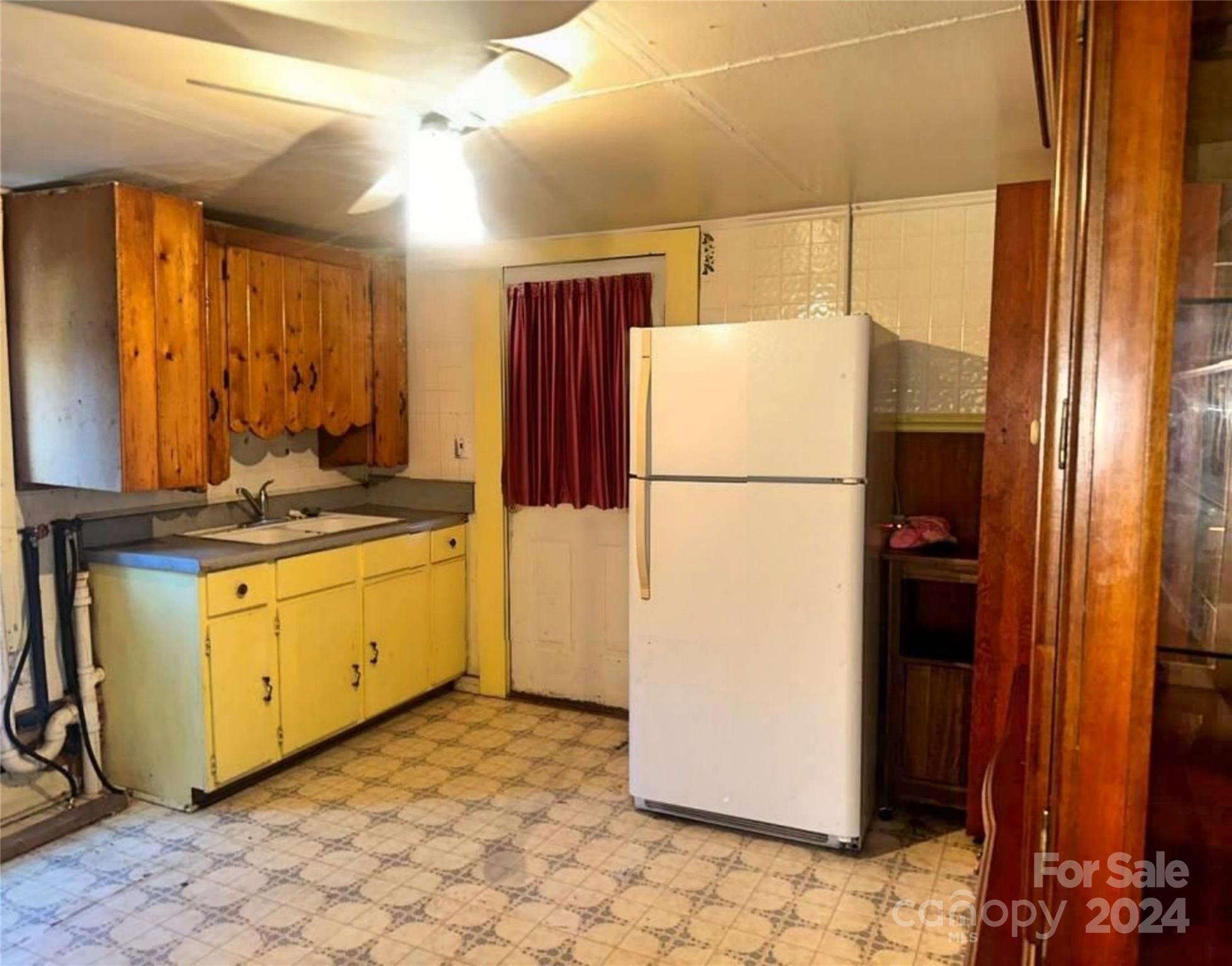 162 Raby Street Canton, NC 28716 - Photo 4 of 8 a white refrigerator freezer and a stove sitting inside of a kitchen