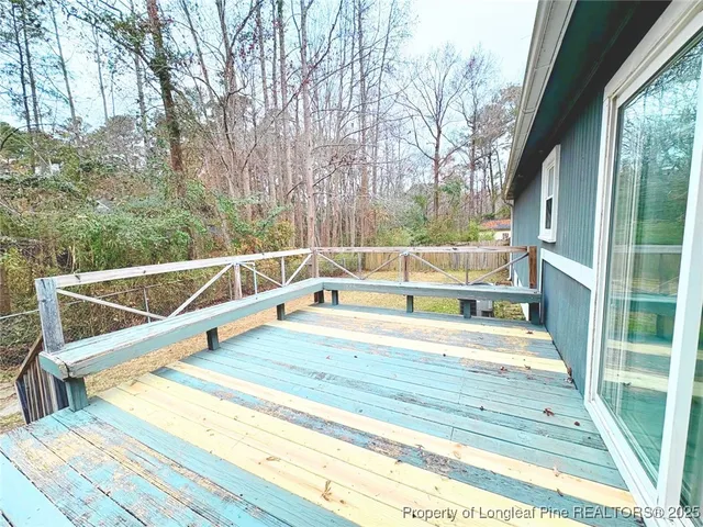 a view of a swimming pool with a patio and wooden fence