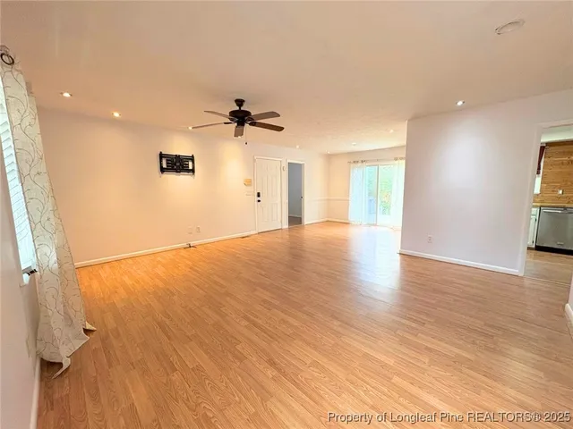 a view of a livingroom with a ceiling fan window and hardwood floor
