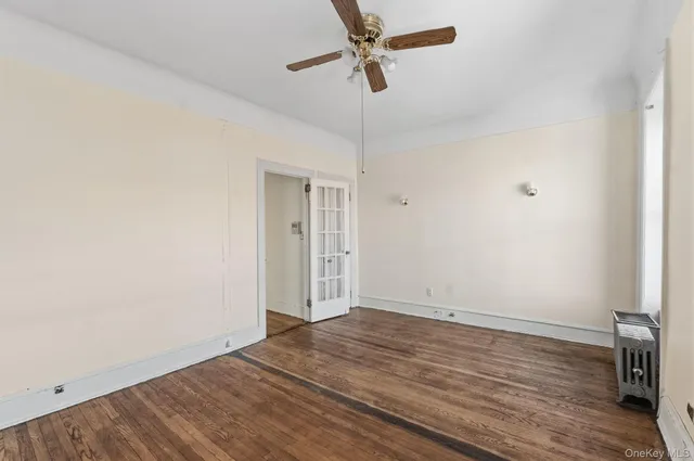a view of room with wooden floor and ceiling fan