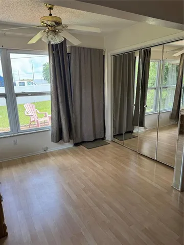 a view of a backyard with lawn chairs under an umbrella