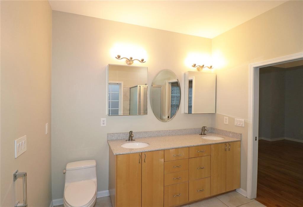 100 Wiley Hills Trail Woodstock, GA 30188 - Photo 19 of 39 a bathroom with a double vanity sink and mirror
