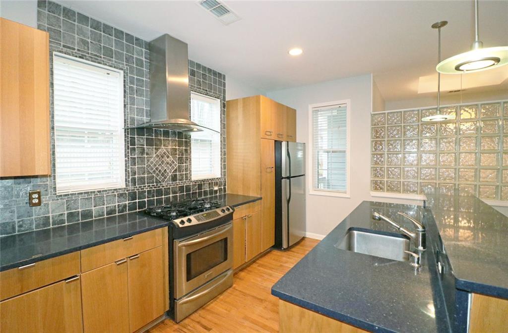 100 Wiley Hills Trail Woodstock, GA 30188 - Photo 8 of 39 a kitchen with stainless steel appliances granite countertop a sink stove and refrigerator