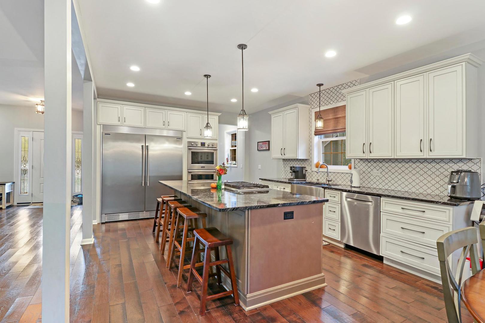39247 Rangers Way Antioch, IL 60002 - Photo 12 of 33 a kitchen with stainless steel appliances granite countertop a sink a stove a refrigerator and island with wooden floor