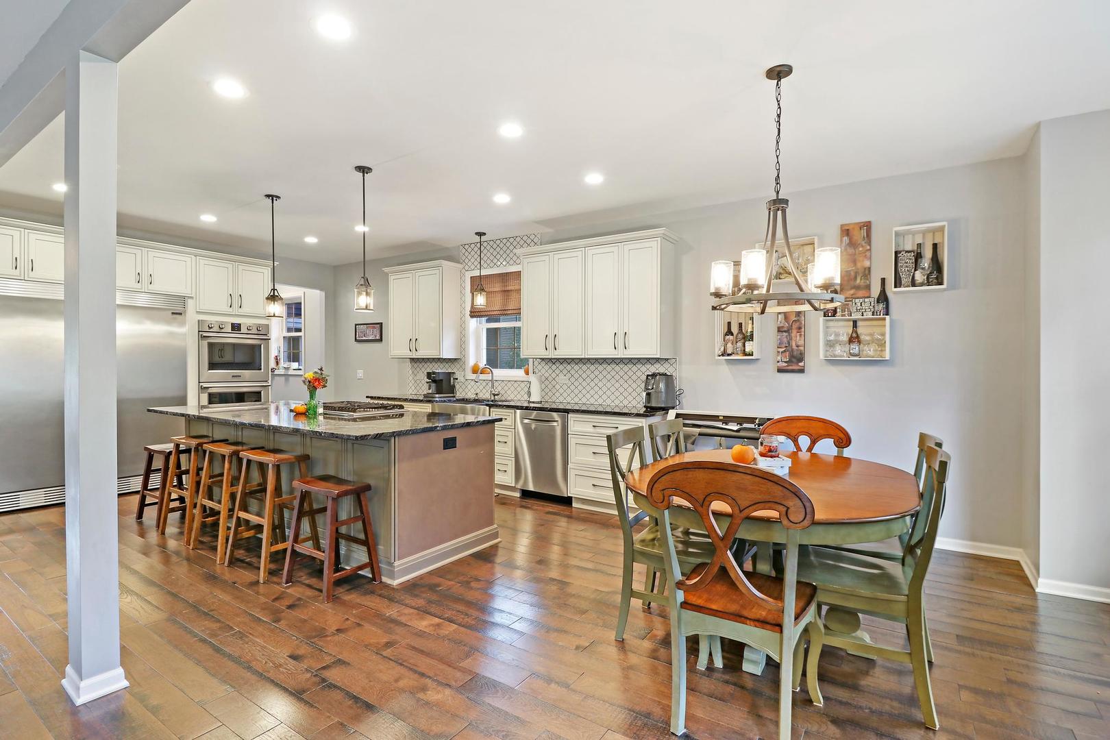 39247 Rangers Way Antioch, IL 60002 - Photo 13 of 33 a kitchen with stainless steel appliances granite countertop a dining table chairs and sink
