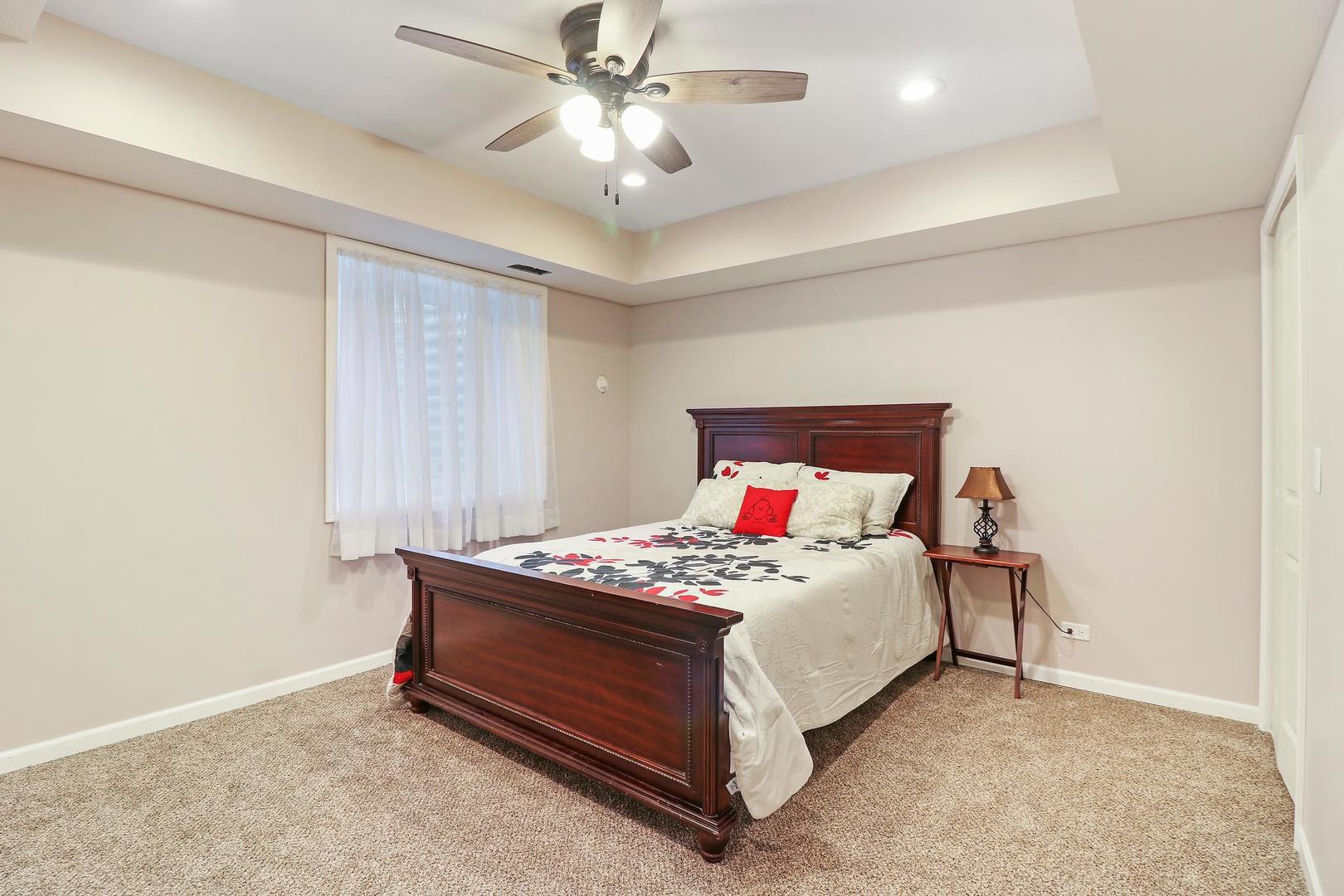 39247 Rangers Way Antioch, IL 60002 - Photo 30 of 33 a bedroom with a bed and a chandelier