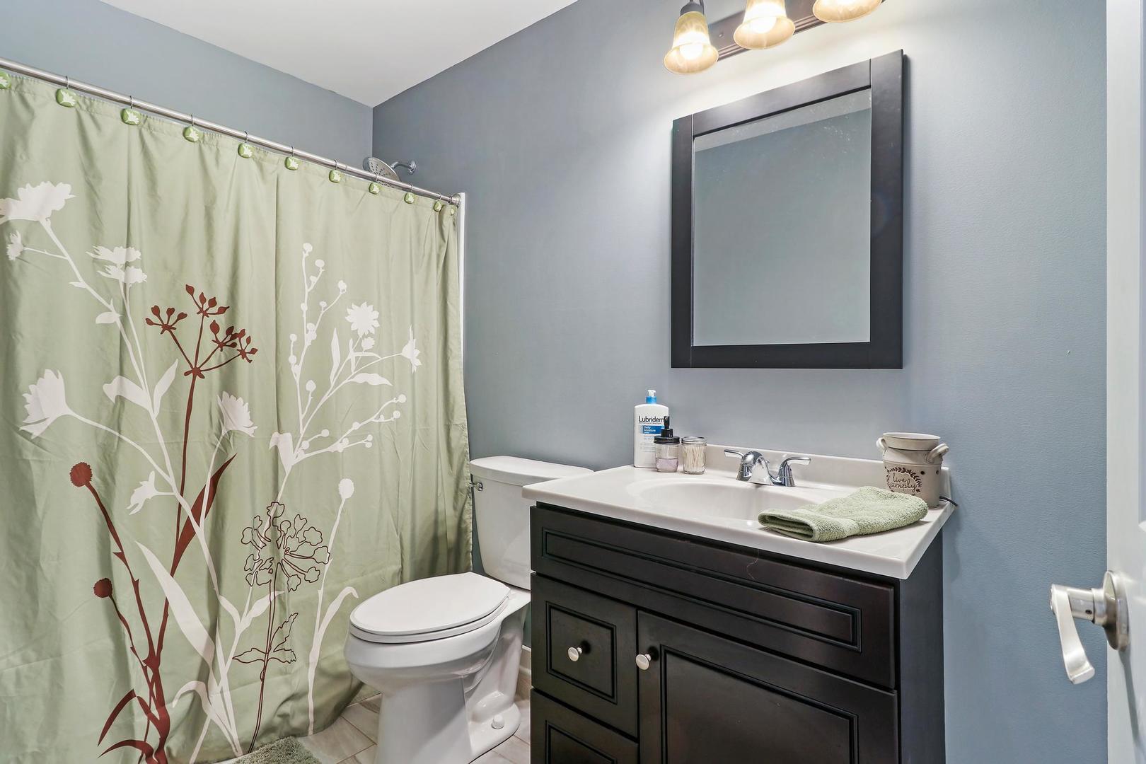39247 Rangers Way Antioch, IL 60002 - Photo 31 of 33 a bathroom with a sink a toilet and shower curtain