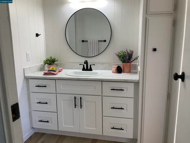 a bathroom with a sink vanity granite and a mirror