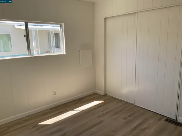 a bedroom with a bed and a painting on the wall