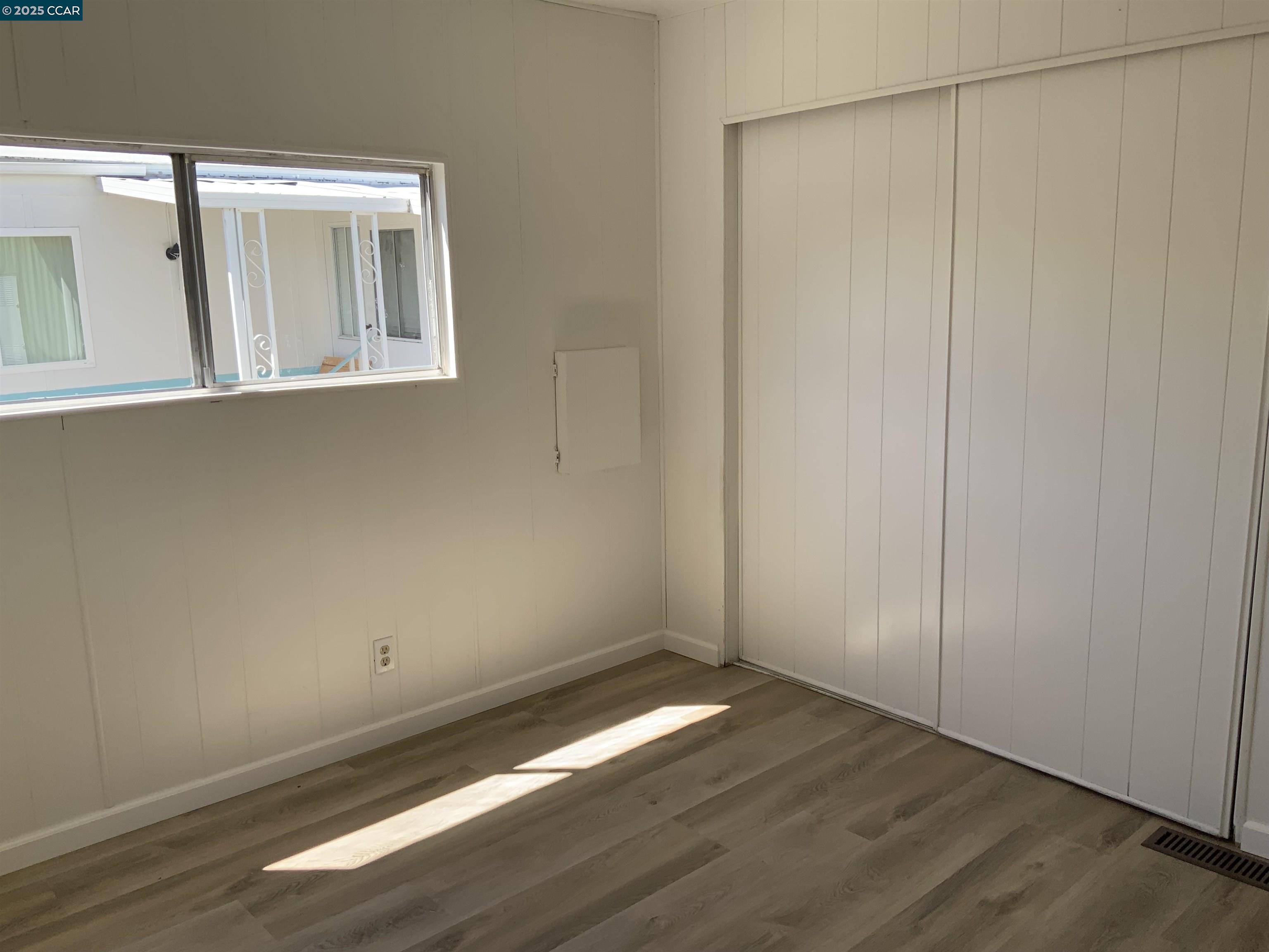 165 Tiki Lane Pittsburg, CA 94565 - Photo 16 of 28 an empty room with wooden floor and windows