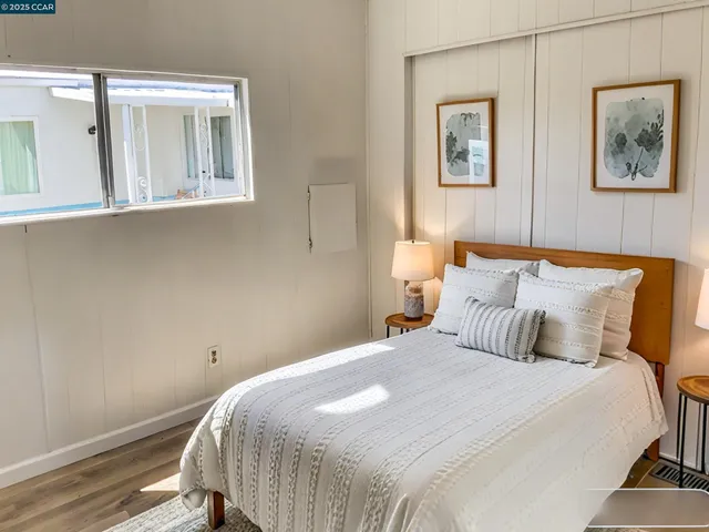 a bedroom with a bed and a painting on the wall