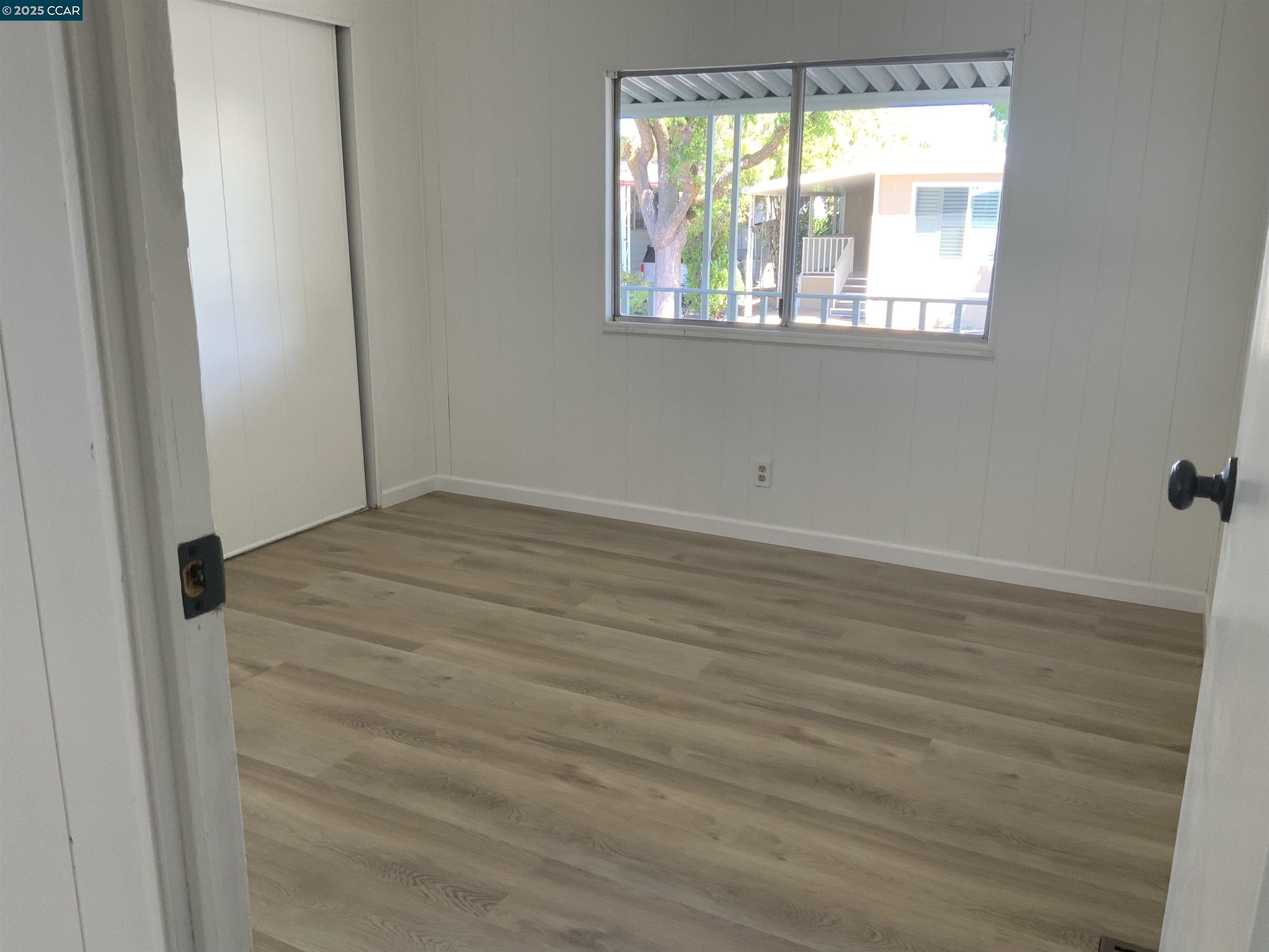 165 Tiki Lane Pittsburg, CA 94565 - Photo 18 of 28 an empty room with wooden floor and windows