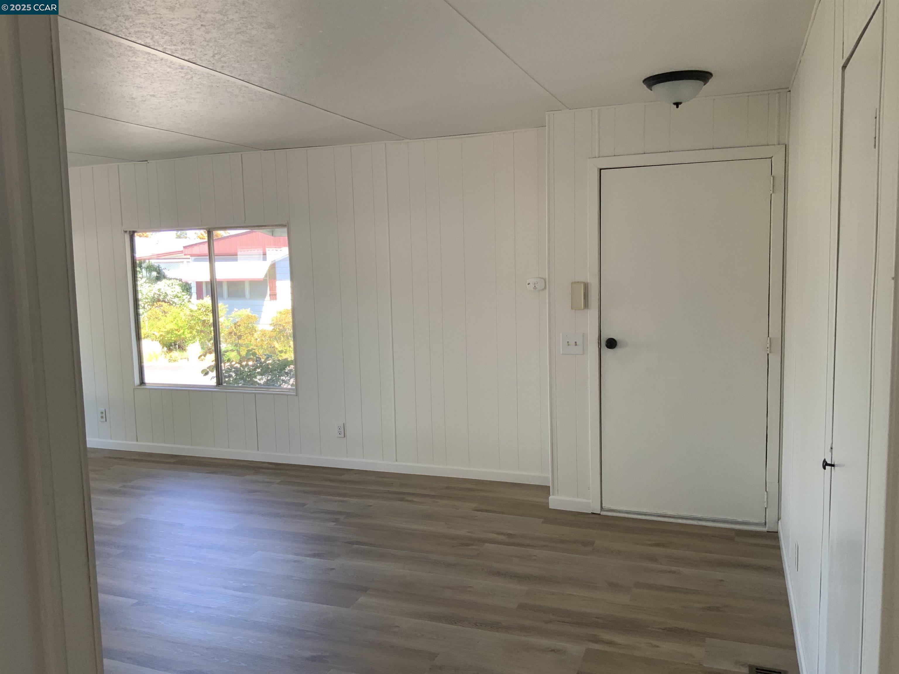 165 Tiki Lane Pittsburg, CA 94565 - Photo 23 of 28 a view of an empty room with wooden floor and a window
