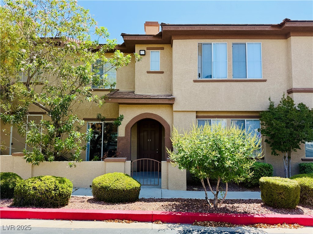 Mediterranean / spanish-style home with a fenced front yard, stucco siding, and a gate