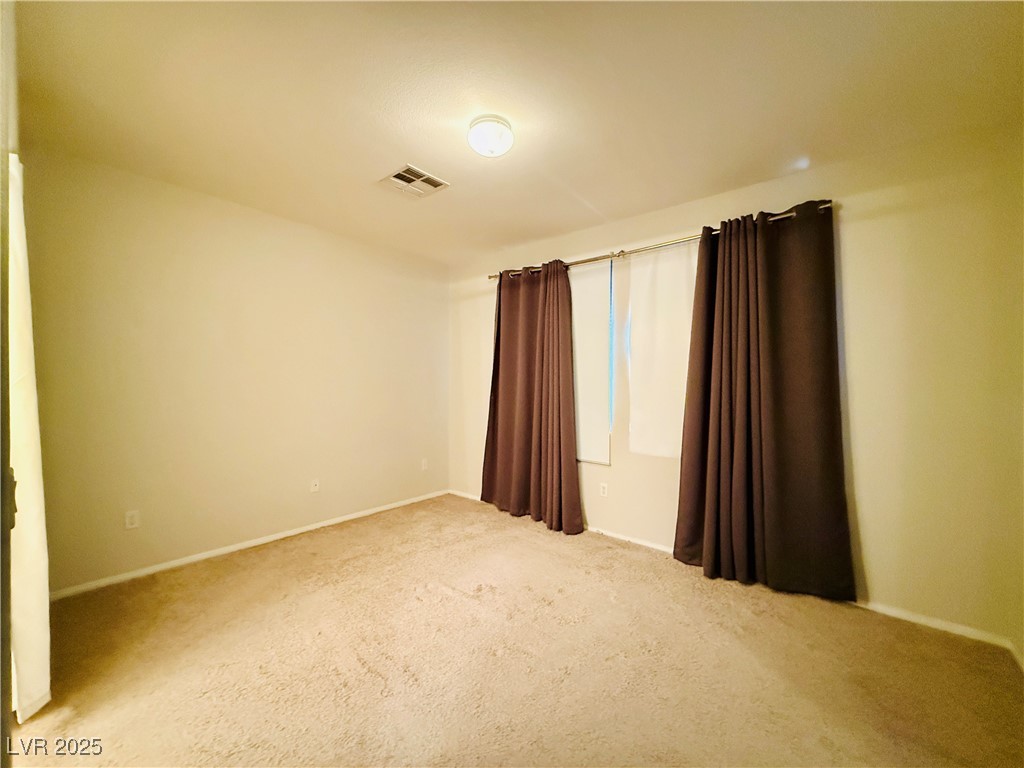 10231 Deerfield Beach Avenue, Unit 103 Las Vegas, NV 89129 - Photo 17 of 31 Empty room with light carpet and baseboards