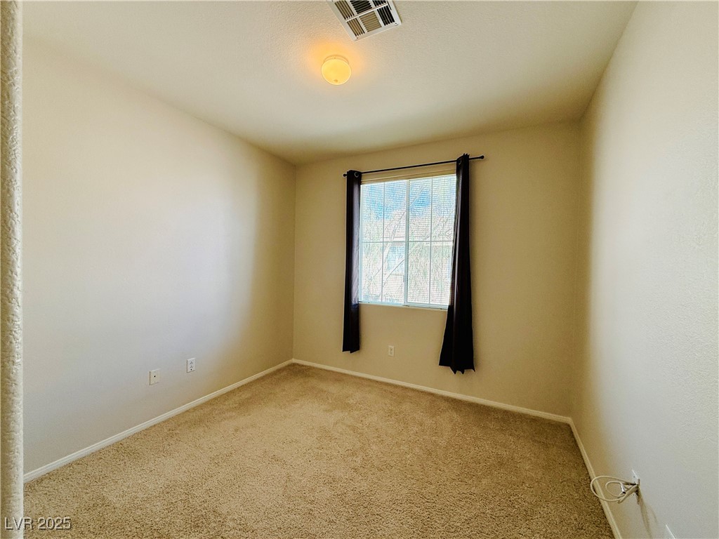 10231 Deerfield Beach Avenue, Unit 103 Las Vegas, NV 89129 - Photo 22 of 31 Carpeted spare room featuring baseboards