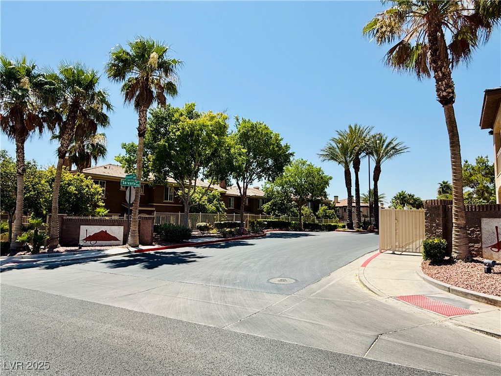 10231 Deerfield Beach Avenue, Unit 103 Las Vegas, NV 89129 - Photo 29 of 31 View of asphalt road with curbs, sidewalks, a gate, a gated entry, and a residential view