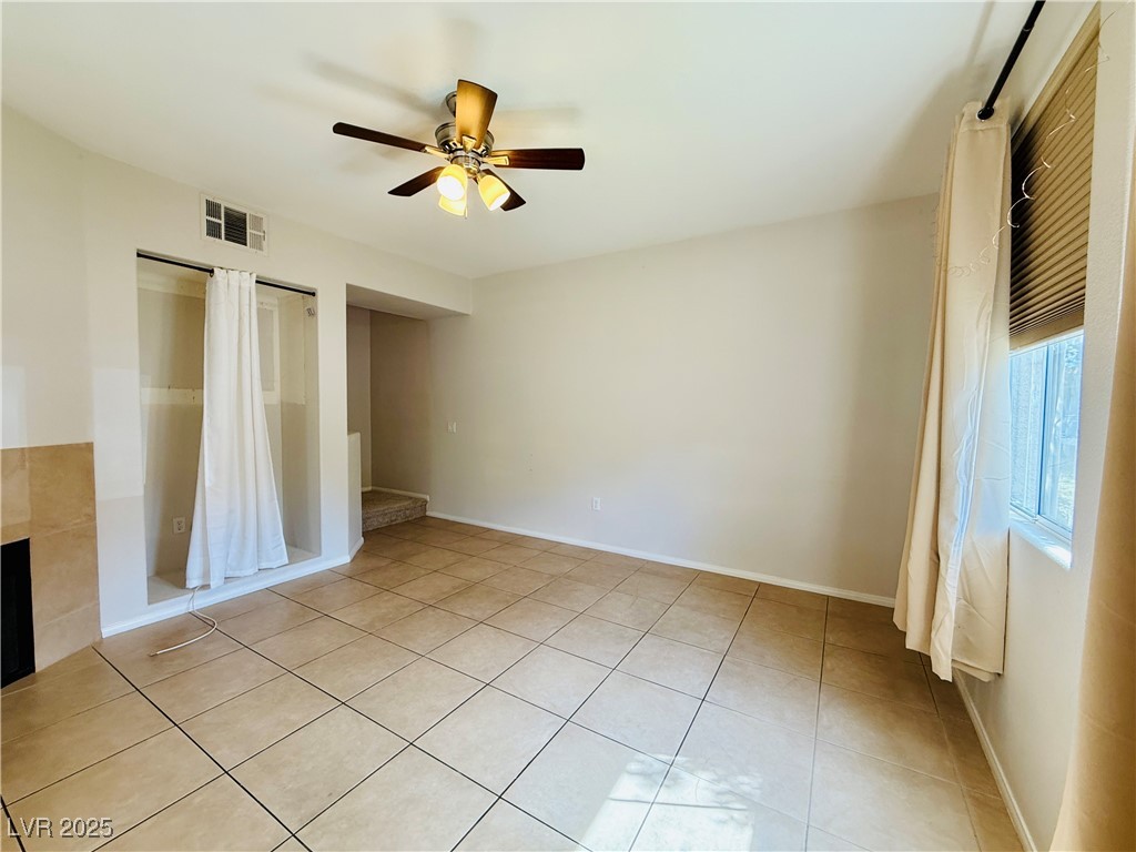 10231 Deerfield Beach Avenue, Unit 103 Las Vegas, NV 89129 - Photo 4 of 31 Unfurnished bedroom with light tile patterned flooring, a ceiling fan, and a closet
