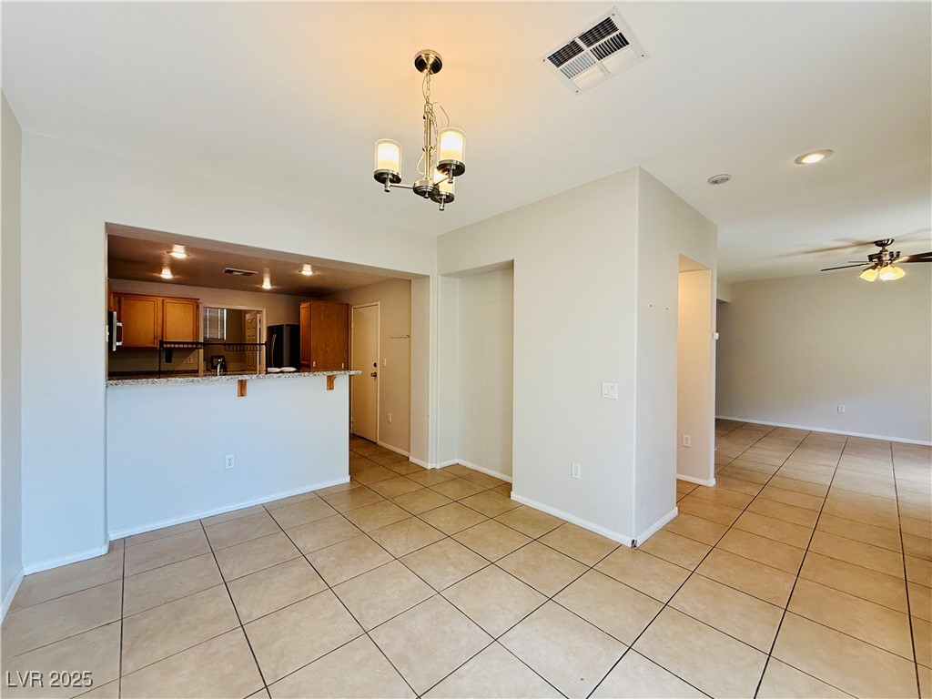 10231 Deerfield Beach Avenue, Unit 103 Las Vegas, NV 89129 - Photo 8 of 31 Unfurnished living room with light tile patterned floors, a chandelier, recessed lighting, and ceiling fan