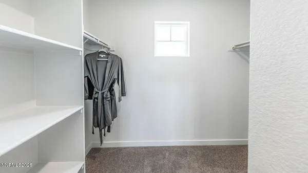 a view of walk in closet with clothes