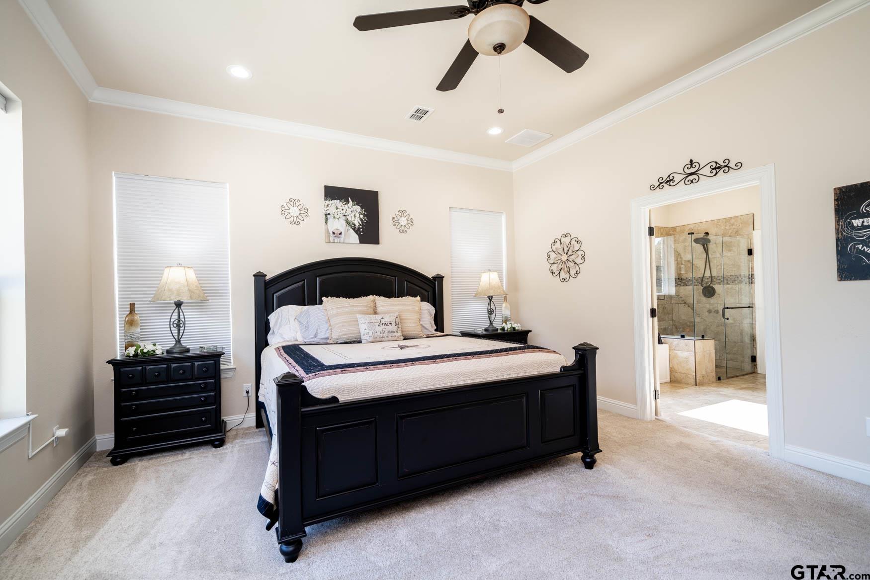 343 Driskell Bridge Road Harleton, TX 75651 - Photo 15 of 42 a spacious bedroom with a bed and ceiling fan