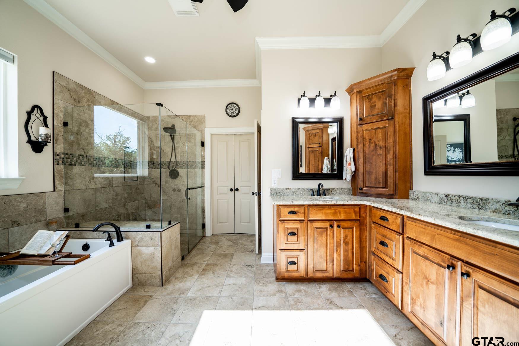 343 Driskell Bridge Road Harleton, TX 75651 - Photo 16 of 42 a large bathroom with a tub a sink and a large mirror