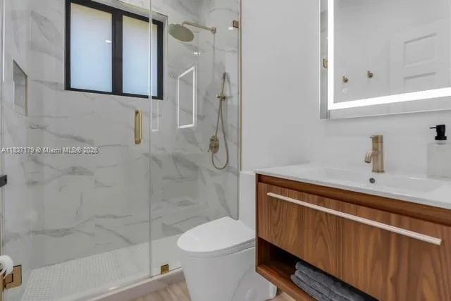 a bathroom with a sink a toilet and shower